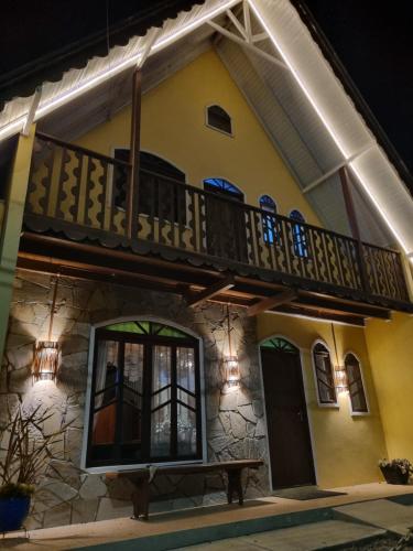 a house with a balcony on top of it at Pousada girassol in Urubici