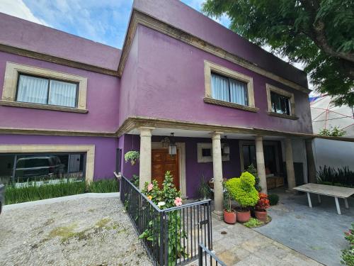a purple house with a bench in front of it at Casa Monasterio in Mexico City