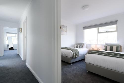 a hotel room with two beds and a window at Modern Ease in East Devonport in Devonport