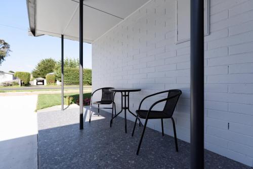 a patio with two chairs and a table at Modern Ease in East Devonport in Devonport