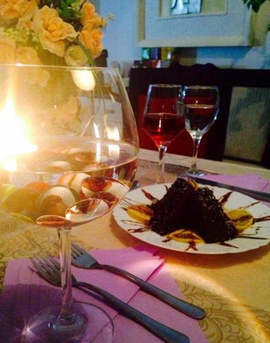 a table with a glass of wine and a piece of cake at Villa Bella Boutique Hotel in Kavadarci