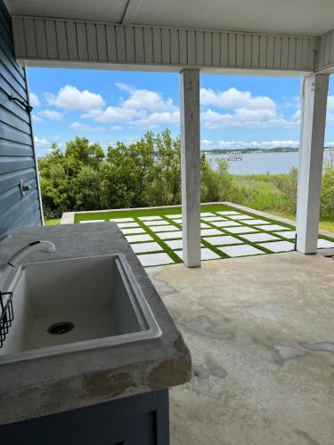 a sink on a patio with a view of the water at Harkers Hideaway - Waterfront with Private Beach in Harkers Island