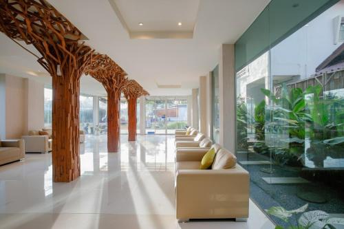 a lobby with a row of couches and plants at The Wings Boutique Hotels Krabi Ko Lanta in Ko Lanta
