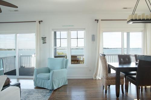a living room with a blue chair and a table at Harkers Hideaway - Waterfront with Private Beach in Harkers Island