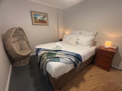 Un pequeño dormitorio con una cama y una silla. en Riverfront, Tiny Home in Natural Bush, en Bridgetown
