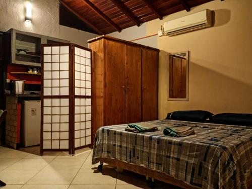 1 dormitorio con 1 cama con manta a cuadros en Karaguashouse, en Florianópolis