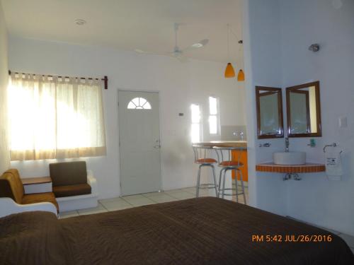 a bedroom with a bed and a table and a kitchen at Hotel y Suites Del Paci­fico in Salina Cruz