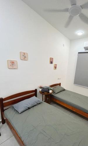 two beds in a room with a projection screen at NEW The Sweet Home Bukit Beruang 3Bed 3Bath in Kampong Sungai Putat
