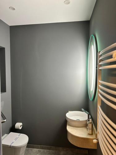 a bathroom with a white toilet and a sink at d'or Hotel in Chişinău