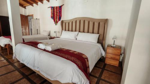 a bedroom with a large bed with a stuffed animal on it at Hospedaje Chaska Pisac in Pisac