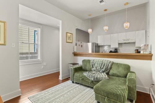 sala de estar con silla verde y cocina en Perfectly Located 1 Bedroom I Uptown - Magazine St, en Nueva Orleans