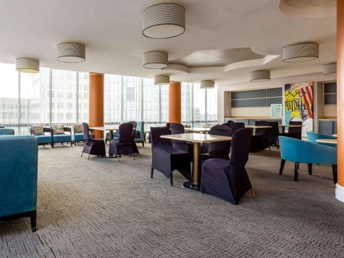 a waiting room with tables and chairs and windows at Comfort Inn & Suites Baltimore Inner Harbor in Baltimore