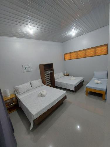 a room with two beds and a couch at BC Lodge in Puerto Princesa City