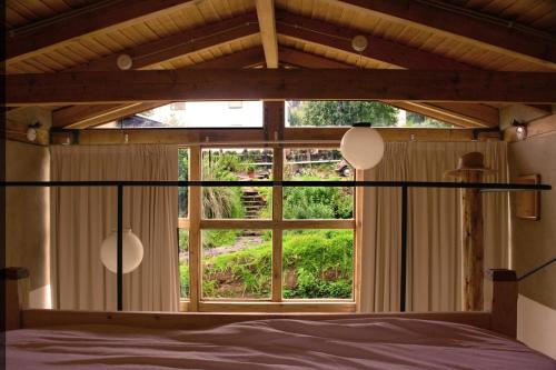 a bedroom with a large window and a bed at Casa de Tierra Loft Ocoxal in San Miguel Ajusco