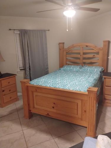 a bedroom with a wooden bed and a ceiling fan at Sky Fresh Home Stay in Apple Valley