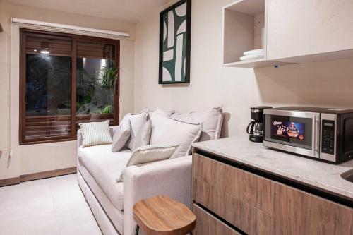 a living room with a couch and a microwave at Stylish Double Studio with Equipped Kitchen and Wi-Fi in Bucerías