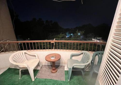 three chairs and a table on a balcony at night at Mahitab music in Cairo