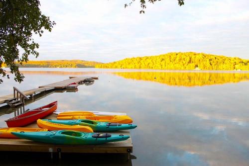 a group of kayaks on a dock on a lake at Colonial Bay Motel and Cottages in Huntsville
