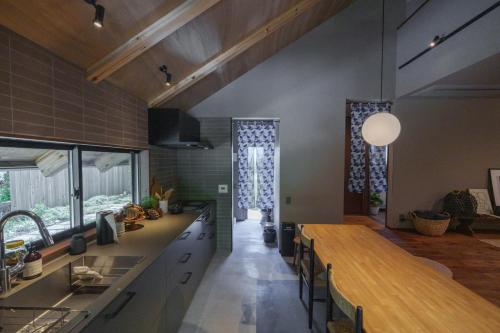a kitchen with a long counter and a table at COCO VILLA 湯布院-Yufuin- in Yufu