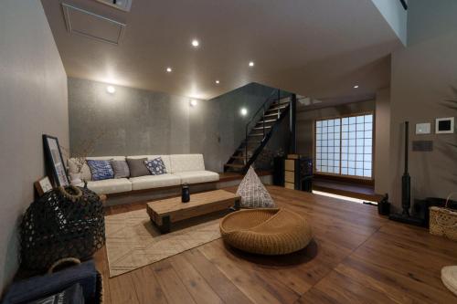 a living room with a couch and a table at COCO VILLA 湯布院-Yufuin- in Yufu
