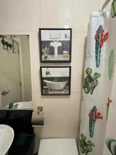 a bathroom with a toilet and a sink and a shower curtain at Cozy Cabin by JLS Near Venice Grand Canal Mall in Manila