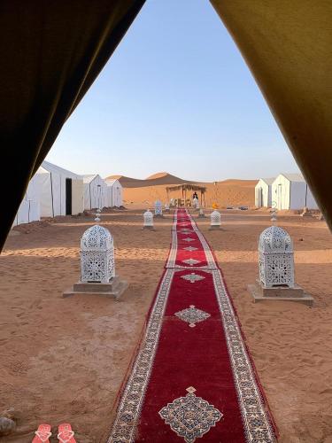 a red carpet in the middle of the desert at Epic Erg Chigaga Desert Camp in El Gouera