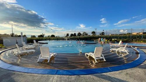 una piscina con sillas blancas y una fuente en Rincón del café, en Montenegro