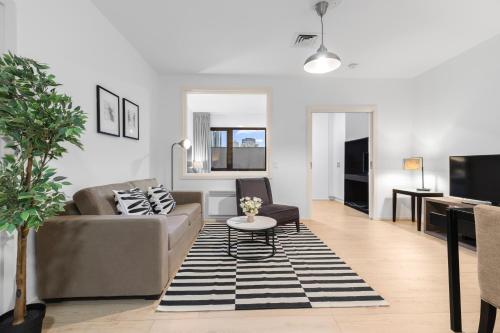 a living room with a couch and a table at Central Emporium Hotel-Style 1BR with King Bed in Melbourne