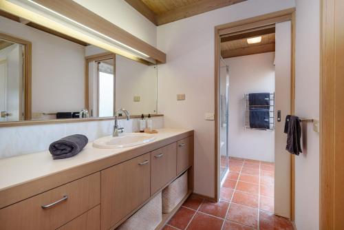 un baño con lavabo y espejo en Queens Beach Retreat - Beachside Coastal Escape, en Sorrento