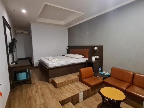a small room with a bed and a couch at Hotel Minahasa Manado in Manado