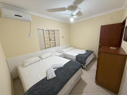 a bedroom with two beds and a ceiling fan at Casa Lua - A melhor localização de Bonito in Bonito