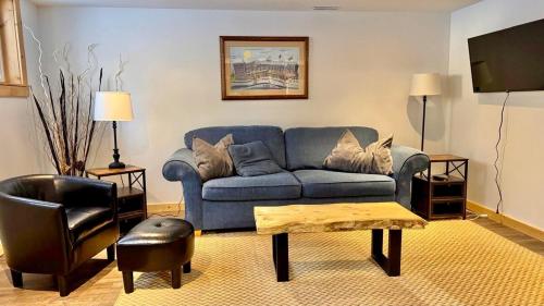 een woonkamer met een blauwe bank en een tv bij Suite on the Bay in Marsh Lake