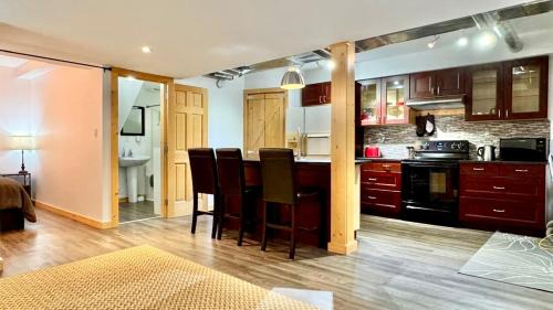 een keuken met een bar met stoelen en een fornuis bij Suite on the Bay in Marsh Lake