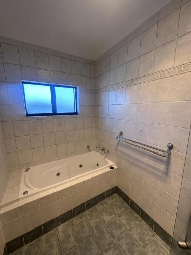 a bathroom with a tub and a window at Spacious Queen Room in Comfortable Two Story House - L2 