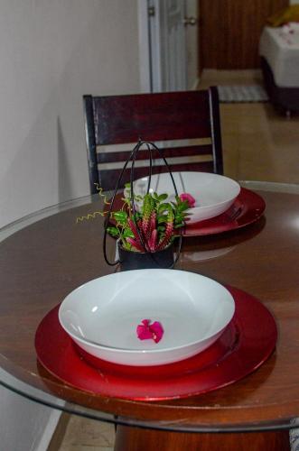 a table with two plates and a plant on it at La posada ideal in Punta Cana