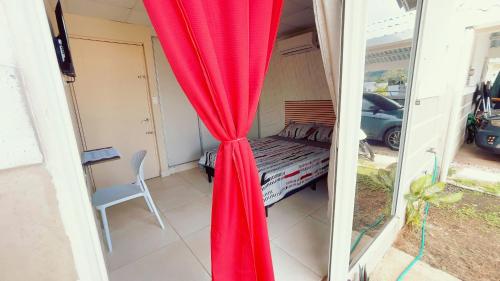 a room with a red curtain and a bed at Habitación privada en Playa Dorada in ArraijÃ¡n