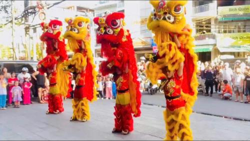 a group of people dressed up in colorful costumes on a street at Khách Sạn Hùng Vương Quảng Ngãi in Quang Ngai