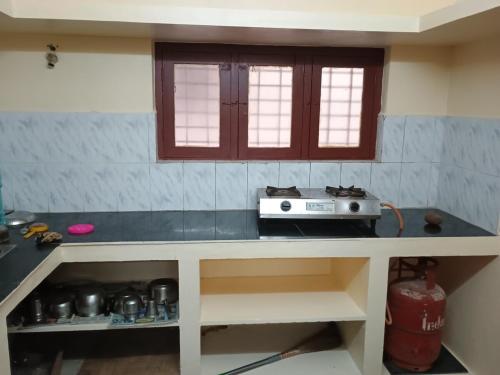 a kitchen with a counter top with a stove at Home away from home in Palakkad in Palakkad