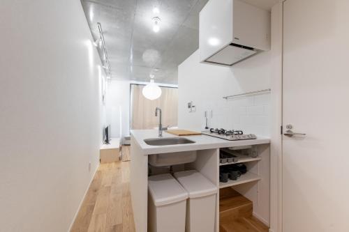 a white kitchen with a sink and a counter at trias527 2-2 in Tokyo