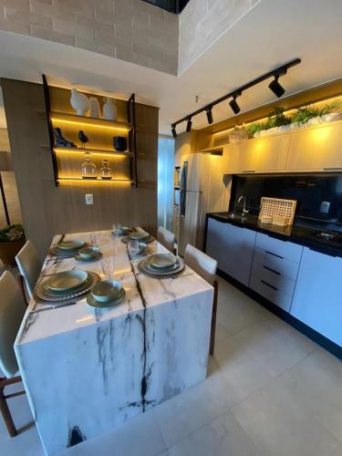 a kitchen with a table with plates on it at Ed. Connext Loft (ref. Hotel Mercure Boulevard) in Curro Velho