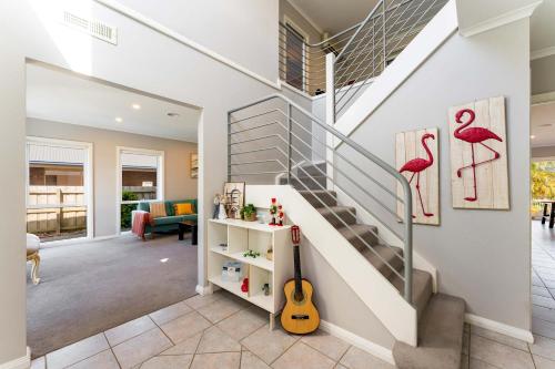 a home with a staircase with a guitar in a living room at Jaw Dropping Waterside Getaway Patterson Lakes in Patterson Lakes