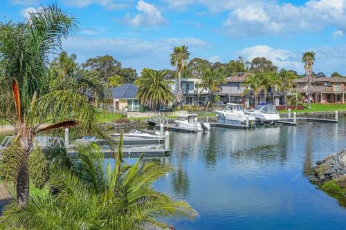 a group of boats docked on a river with houses at Jaw Dropping Waterside Getaway Patterson Lakes in Patterson Lakes