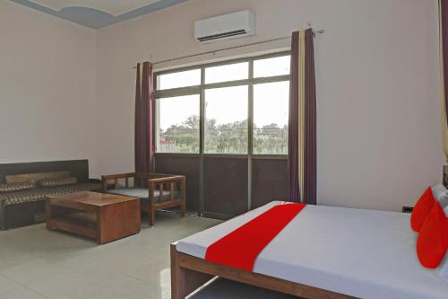 BhauliHotel O Mb Garden & Resorts的一间卧室，里面有一张床和一扇大窗户。