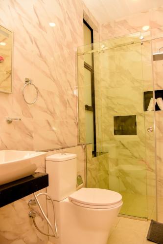 a bathroom with a toilet and a sink and a shower at Urban Nest Apartment in Gampola