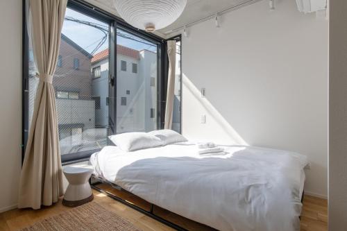 a bedroom with a bed and a large window at trias527 2-2 in Tokyo