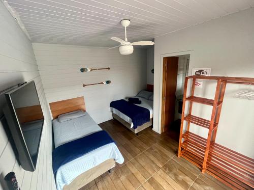 a bedroom with two bunk beds and a ceiling fan at Inn Nature Pousada Casa de Veraneio com piscina in Palhoça