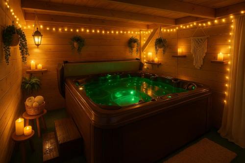 a green bath tub in a room with lights at L'immortel GITE 2 AVEC OU SANS SPA in Cauchy-à-la-Tour