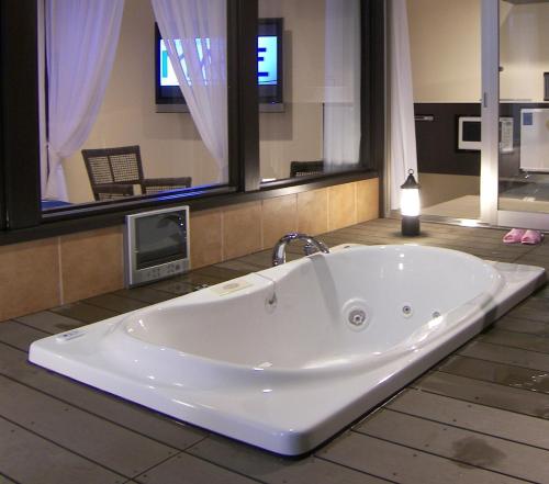 a large white tub in a bathroom with a tv at Hotel Mare - Vacation STAY 24956v in Kure