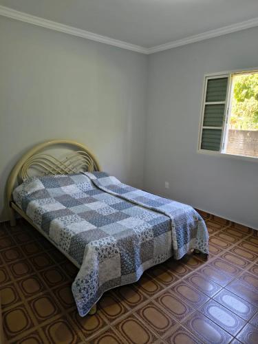 a bedroom with a bed with a checkered blanket on it at Natureza Presente in São Lourenço