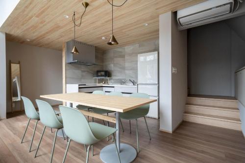 a kitchen and dining room with a wooden table and chairs at ERUSA Rusutsu in Rusutsu